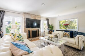 Relax in a comfortable seating area with a sofa, armchair, and flat-screen TV.
