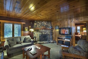 Cozy living room with a fireplace, flat-screen TV, and comfortable seating area.