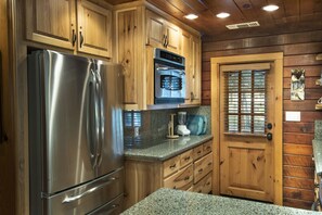 Enjoy cooking in this well-equipped kitchen with a refrigerator, oven, and microwave.