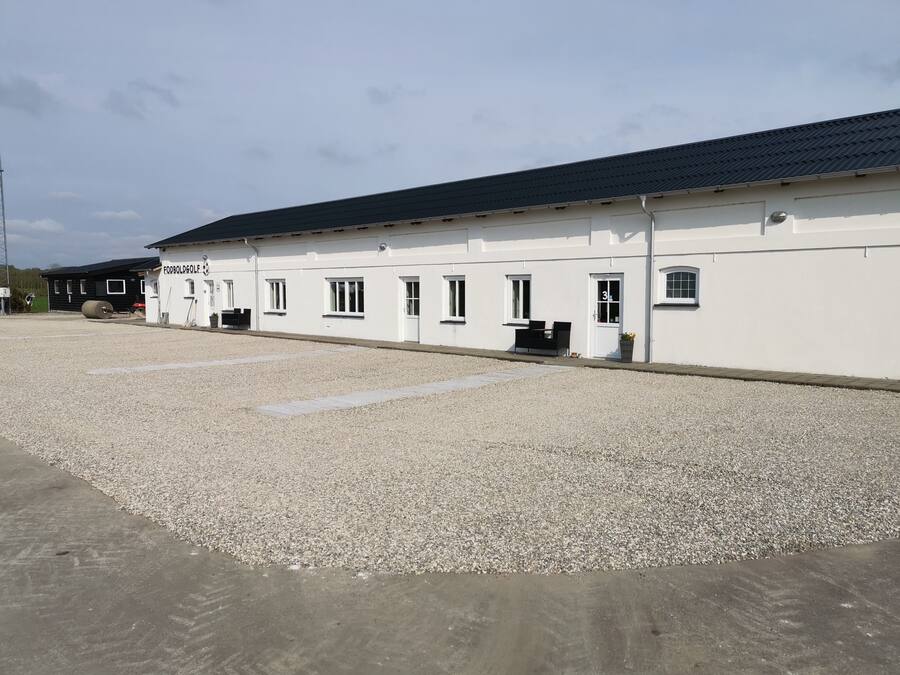 A building with a white exterior and a black roof, labeled "FODBOLDGOLF".