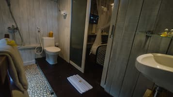 Une salle de bain avec des toilettes, une douche et un lavabo.