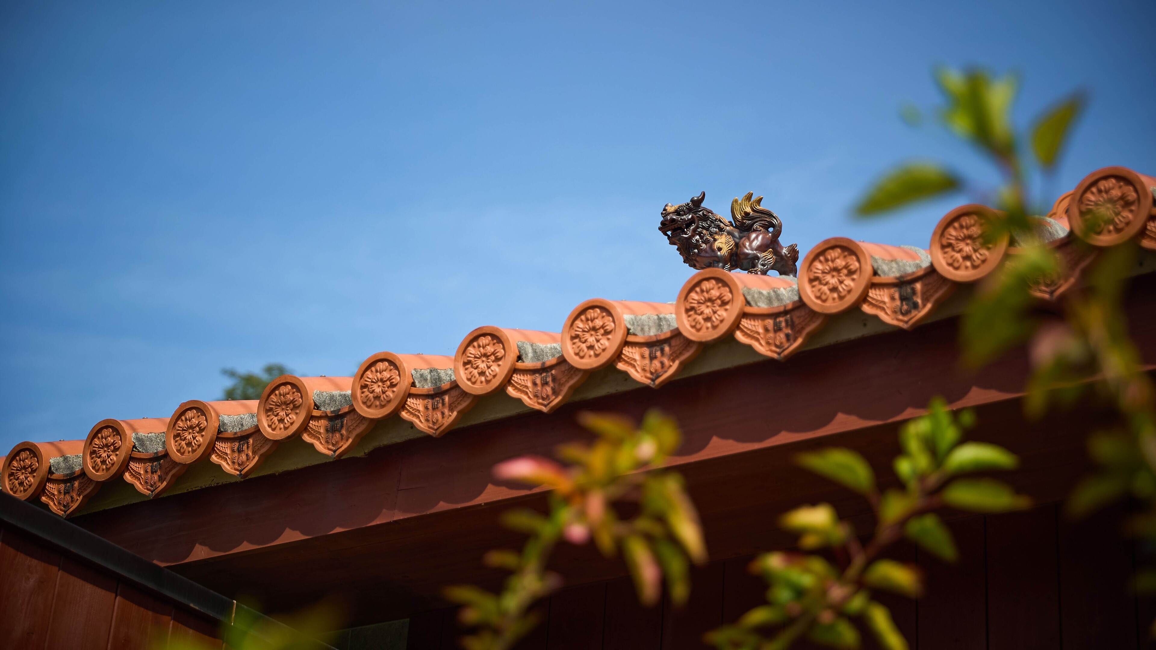 Um telhado de azulejos com detalhes decorativos e uma borboleta pousada nele.