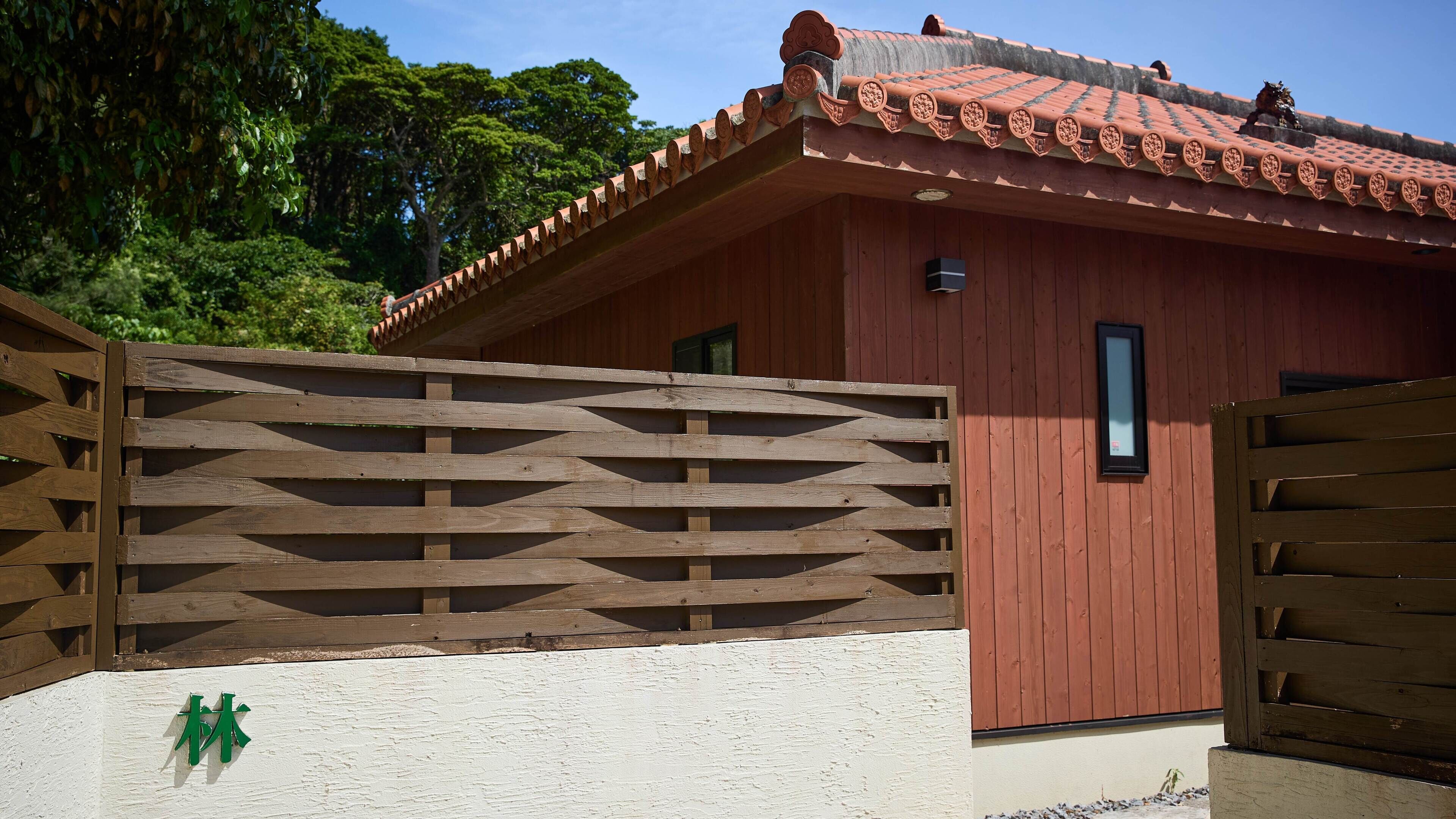 Um edifício tradicional com telhado de azulejos e cerca de madeira.