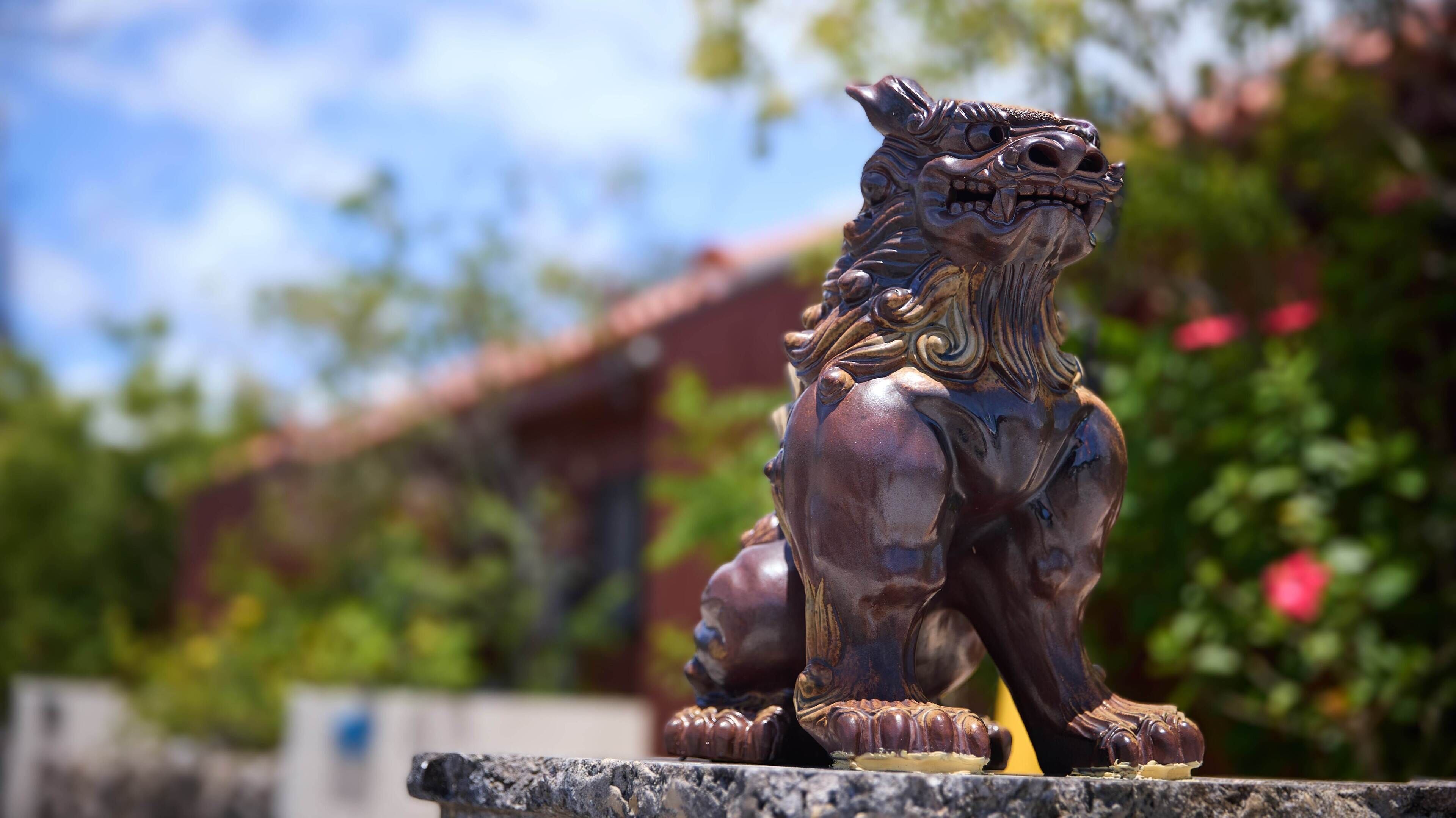 A bronze lion statue on a stone ledge.