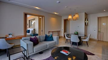 A modern living room with a sofa, coffee table, and dining area.