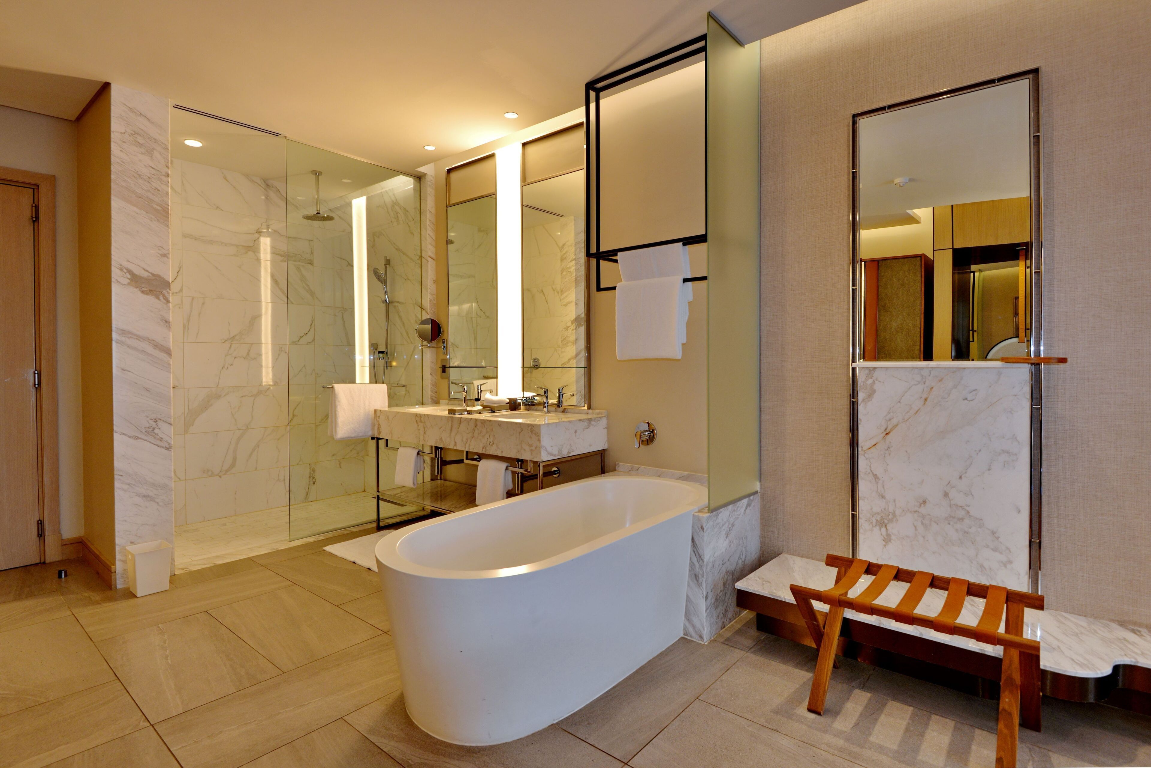 A modern bathroom with a freestanding bathtub, a glass-enclosed shower, and a vanity with a mirror.