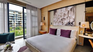 Une chambre d’hôtel moderne avec un grand lit, un bureau et une vue sur le paysage urbain.