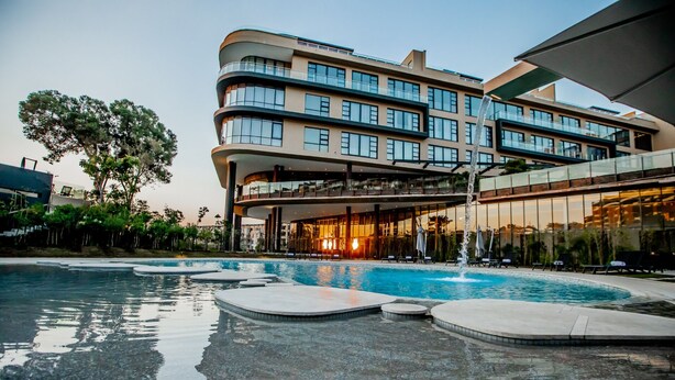 A modern hotel with a pool area, featuring a multi-story building with balconies and large windows. - The Houghton Hotel, Spa, Wellness & Golf (Johannesburg)