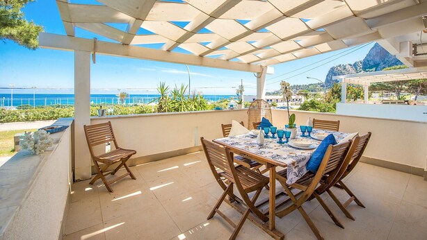 A covered outdoor dining area with a view of the sea and mountains. - Villa Mondello Addaura Sea View (Palermo)