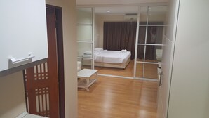 Een hotelkamer met een bed, een klein tafeltje en een schuifdeur naar een balkon.