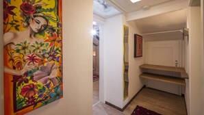 Ein Flur mit einem farbenfrohen Wandgemälde, einer Treppe und einer Tür zu einem weiteren Raum.