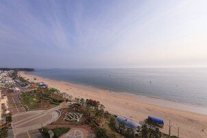A beachside view with a road, buildings, and a clear sky.