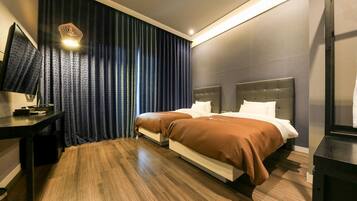 A hotel room with a bed, bedside tables, a desk, and a television.