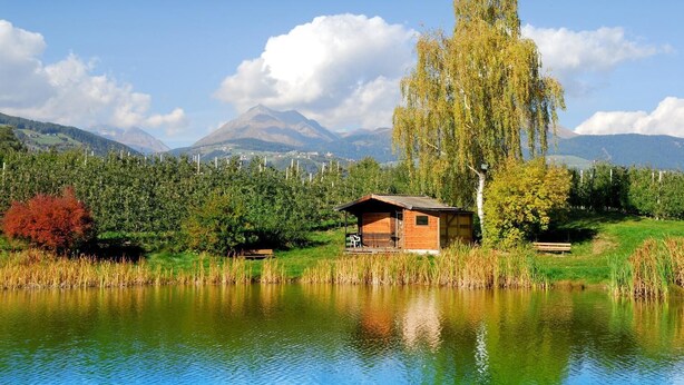 Eine Hütte am See mit einem Berg im Hintergrund.