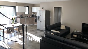 Moderni huoneisto, jossa on keittiö, ruokailutila ja olohuone.