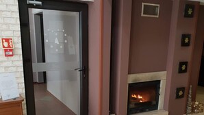 Um quarto com lareira, porta e piso de azulejos.