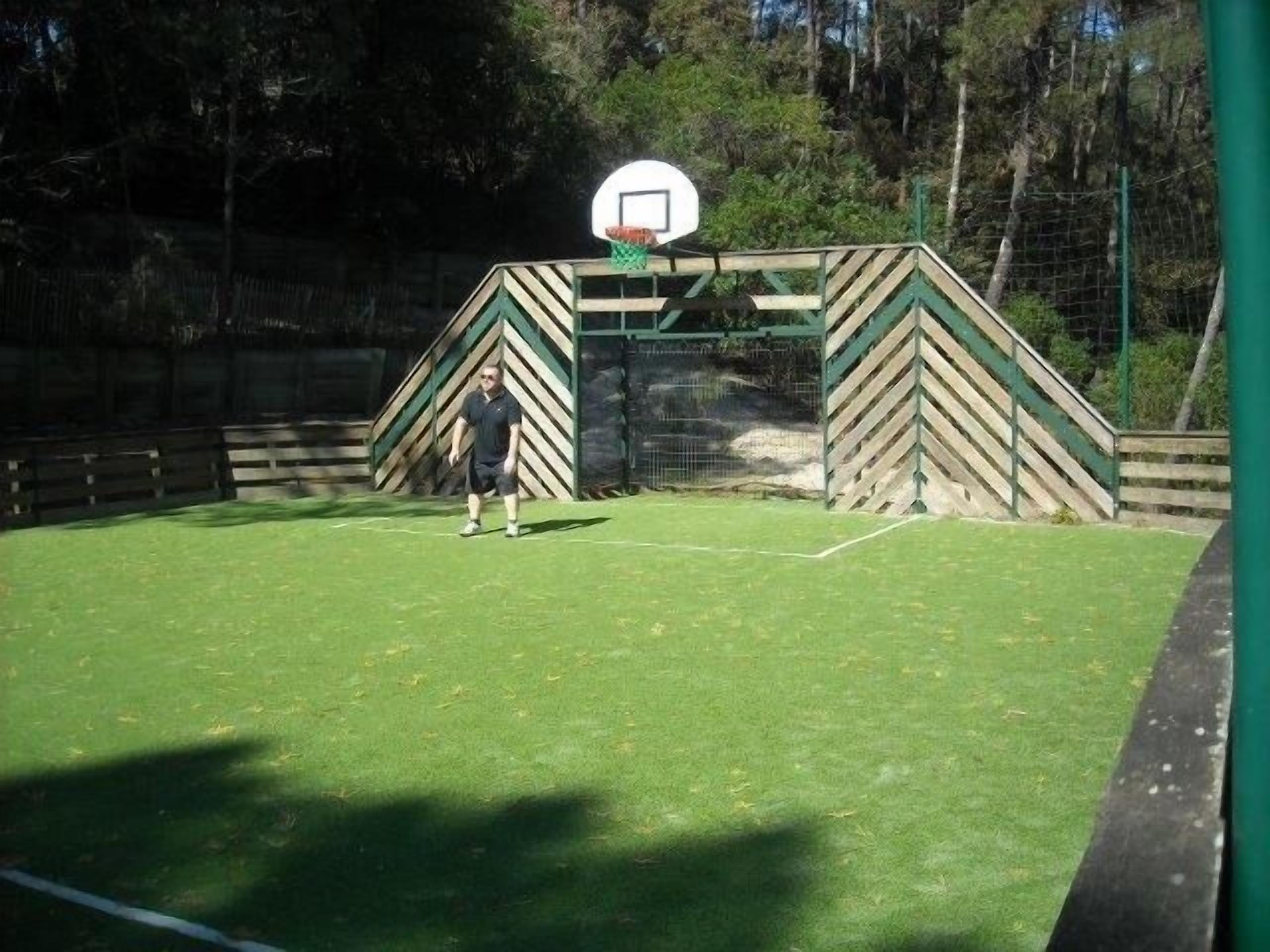 Una cancha de baloncesto con un aro y una persona parada en el centro.