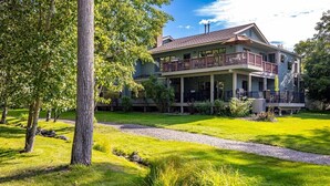 A two-story house with a covered porch and a well-maintained lawn. - Welcome to Mountain Harbor Lakeview Cottage, #137 (Whitefish)
