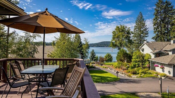 A deck with outdoor furniture and a view of a lake. - Welcome to Mountain Harbor Lakeview Cottage, #137 (Whitefish)