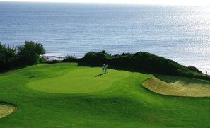 Players tee off with a stunning ocean view.