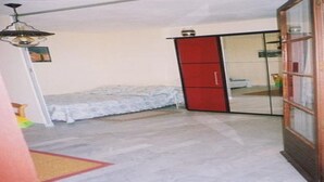 Une chambre à coucher avec un lit, une armoire et un ventilateur de plafond.