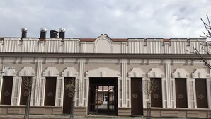 A building with a symmetrical facade, large windows, and a central entrance.
