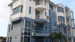 A multi-story building with balconies, air conditioning units, and a blue and white color scheme. - Shikara Apartment (Mombasa)