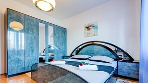 A modern bedroom with a curved bed, a large mirror, and a wardrobe.