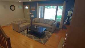 A living room with two sofas, a coffee table, and a staircase. - EAA AirVenture - 5 Bedroom 4 bath 2 Story home at the end of a cul de sac (Appleton)