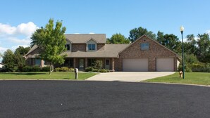 A two-story house with a brick exterior, a garage, and a front lawn. - EAA AirVenture - 5 Bedroom 4 bath 2 Story home at the end of a cul de sac (Appleton)