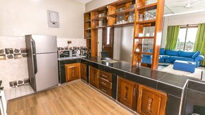 Een moderne keuken met houten kastjes, een roestvrijstalen koelkast en een zwart aanrecht.