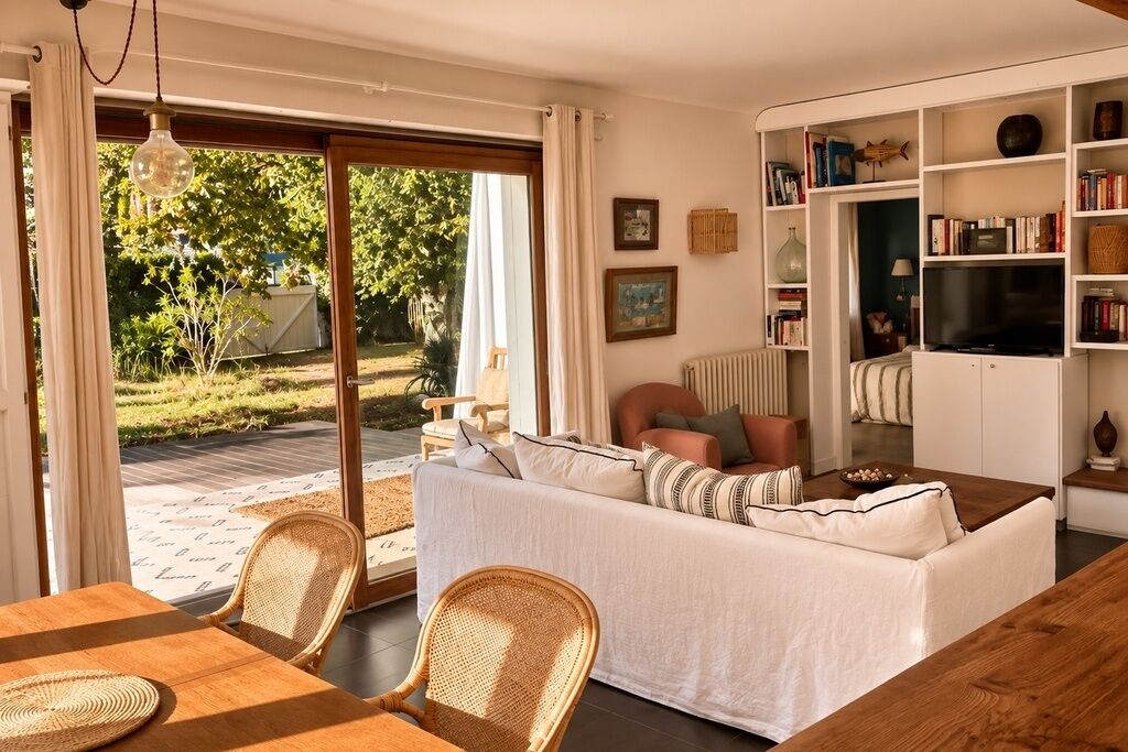Ein Wohnzimmer mit einer Couch, Sesseln, einem Tisch und einem Bücherregal.