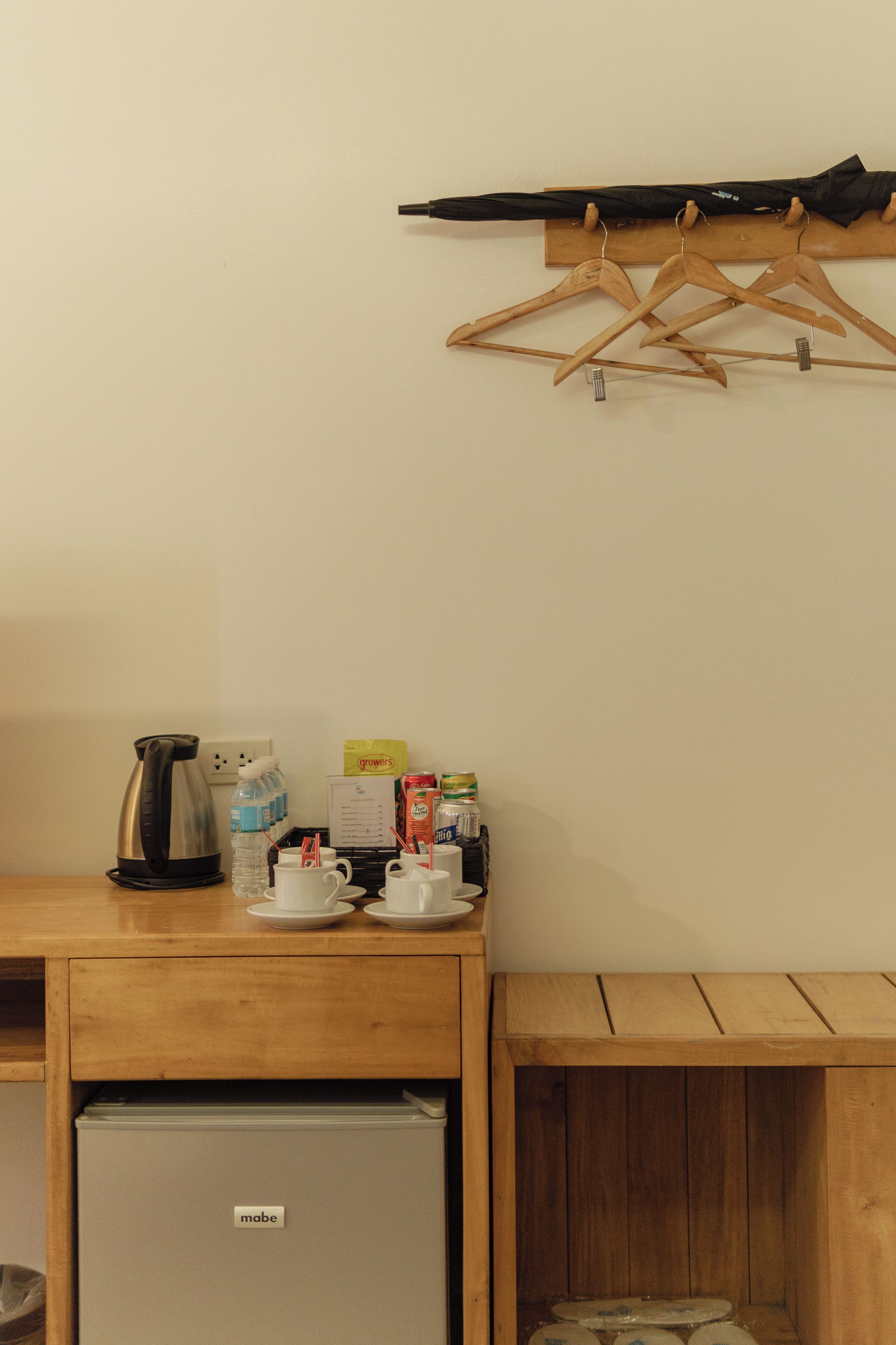 Une petite cuisine équipée d’une machine à café, de bouteilles d’eau et d’un mini-réfrigérateur.