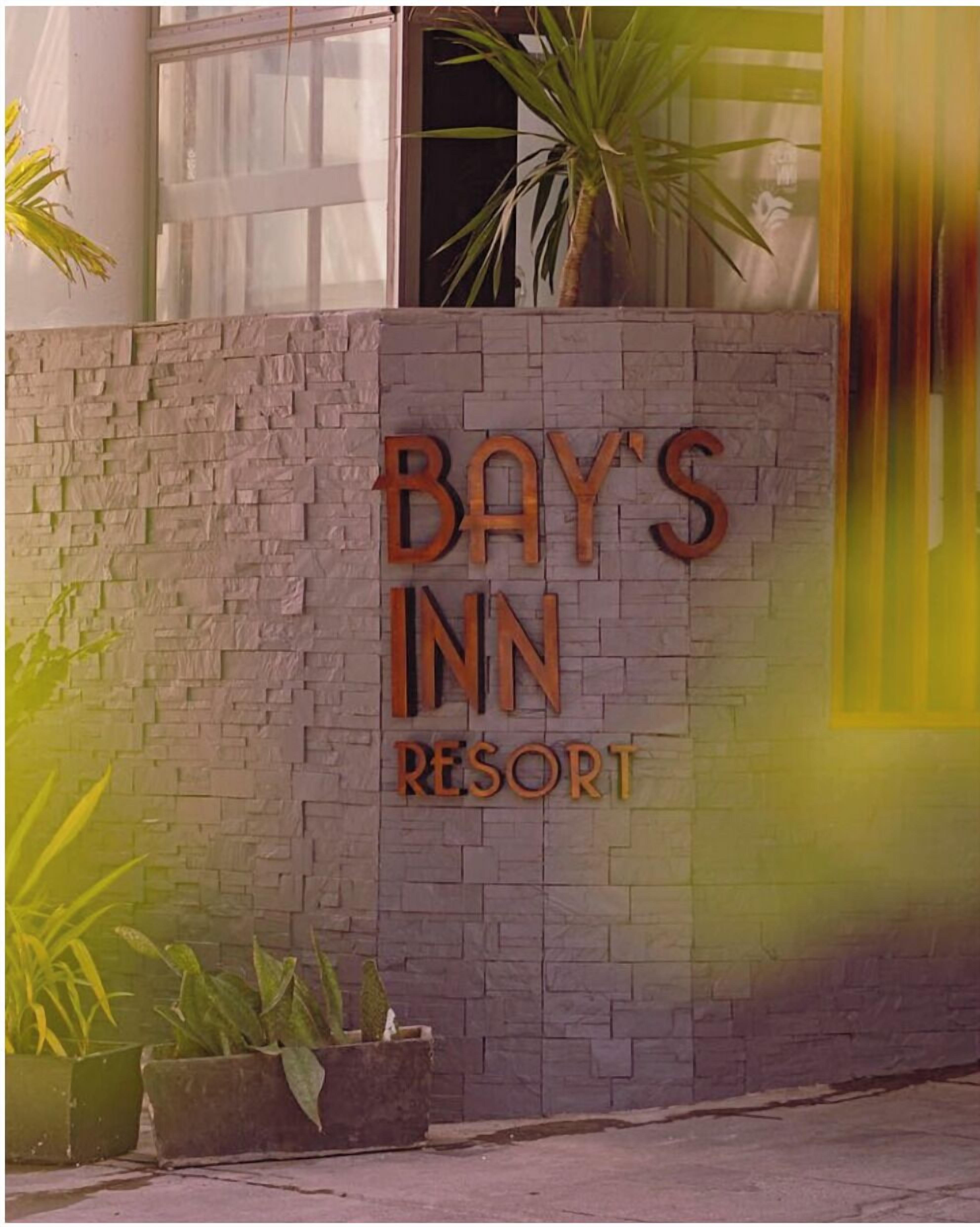 Una pared con el texto "BAY'S INN RESORT" en letras grandes y negritas.