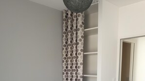 A bedroom with a bed, a wardrobe, and a door leading to another room. - Pretty little house in La Tremblade (La Tremblade)