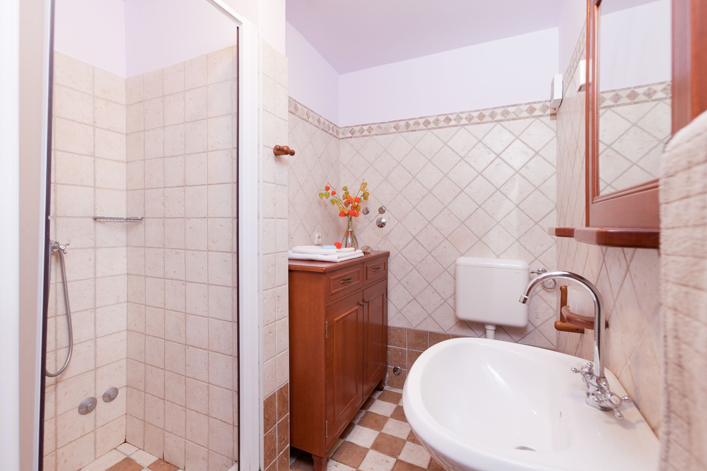 Une salle de bain équipée d’une douche, d’un lavabo, de toilettes et d’un meuble en bois.