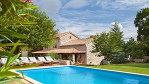 A swimming pool with lounge chairs, a stone building, and surrounding greenery. - Wonderful, secluded, minutes from the beach, with 5 bedrooms (Labin)