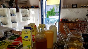 Ein reichhaltiges Frühstücksbuffet mit verschiedenen Speisen und Getränken, darunter frisches Obst, Müsli und Saft.