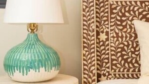A bed with a patterned headboard, a bedside lamp, and a pillow. - Boho Lux (Atlanta)