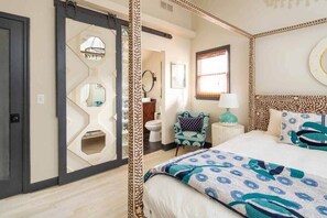 Un dormitorio con cama, una silla, una mesita de noche y una ventana con persianas.