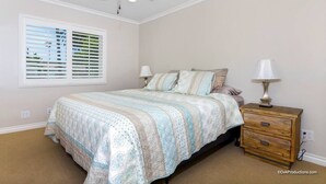 A bedroom with a bed, two bedside lamps, a wooden nightstand, and a ceiling fan. - Perfect Location | Fantastic Home | Near Beach! (Oceanside)