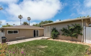 A single-story house with a front yard, a patio, and a small garden area.