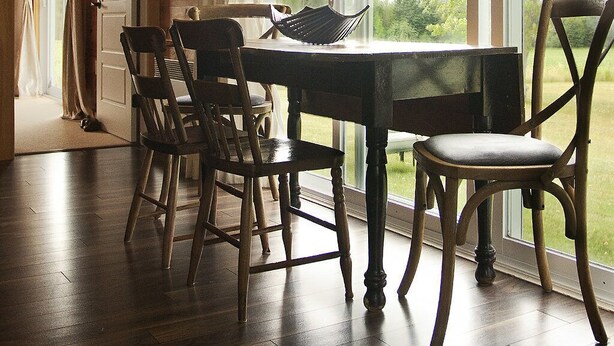 A dining area with a wooden table and chairs, large windows with curtains, and a view of greenery outside. - Relax, Connect & Enjoy with AC at private Oasis. (Long Creek)