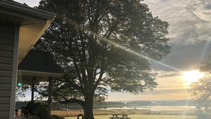 A house with a porch, a large tree, and a picnic table in a grassy area. - Relax, Connect & Enjoy with AC at private Oasis. (Long Creek)