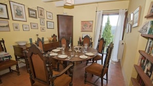 A dining room with a round table set for six, surrounded by wooden chairs. - Celler Colltor (Santa Maria d'Oló)