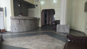A lobby with a reception desk, a seating area, and a staircase leading to an upper level. - D'Luxx Villa & Suites (Lagos)