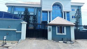 A large, two-story house with a prominent arched window and a small attached garage. - D'Luxx Villa & Suites (Lagos)