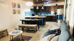 Uma sala de estar moderna com sofá, mesa de centro e área de jantar.