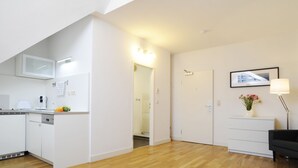A modern apartment with a kitchen, a dining area, and a living room. - homefortimes Frankfurt-Airport (Langen)