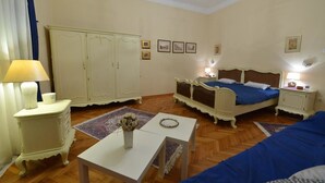 A bedroom with two beds, a wardrobe, a bedside table with a lamp, and a small table with a vase. - Apartment Markovic (Belgrade)